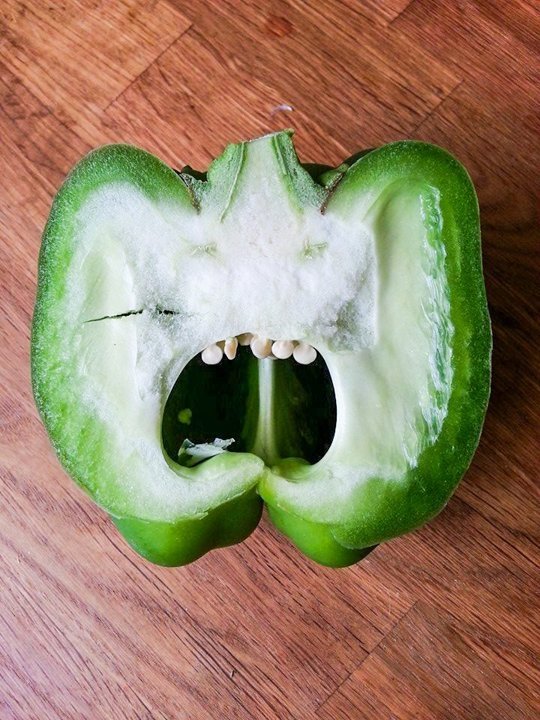 Green pepper cut in half with seeds visible. 