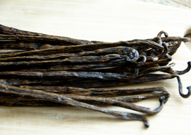 Stack of vanilla beans on wood board