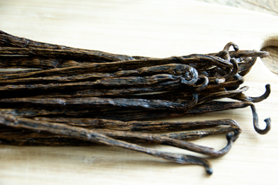 Stack of vanilla beans on wood board