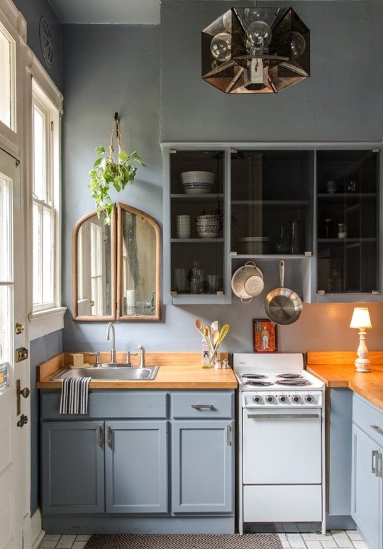 Blue kitchen with small table lamp and mirror