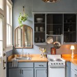 Blue kitchen with small table lamp and mirror