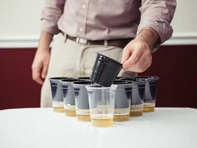 Slip Cup Going into Clear Plastic Cup Filled with Beer for Beer Pong