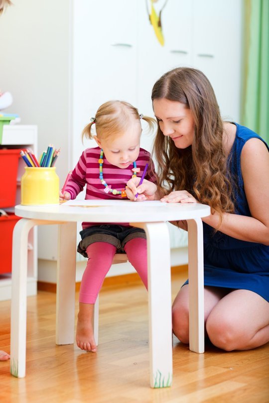 Babysitter and child drawing a picture.