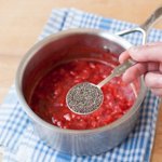 Adding chia seeds to the strawberries.