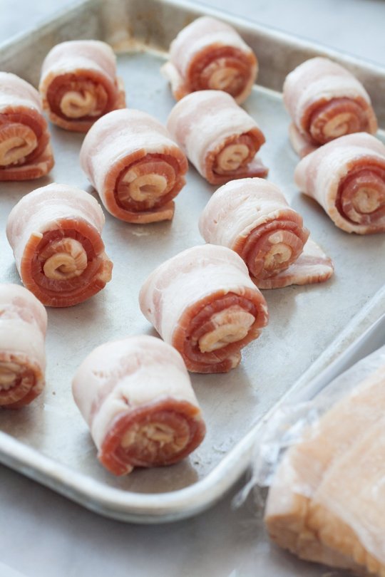 Coiled bacon on a sheet pan with more bacon.