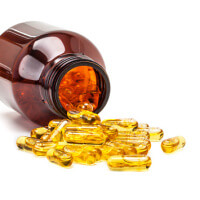 fish oil capsules spilling out from brown glass bottle